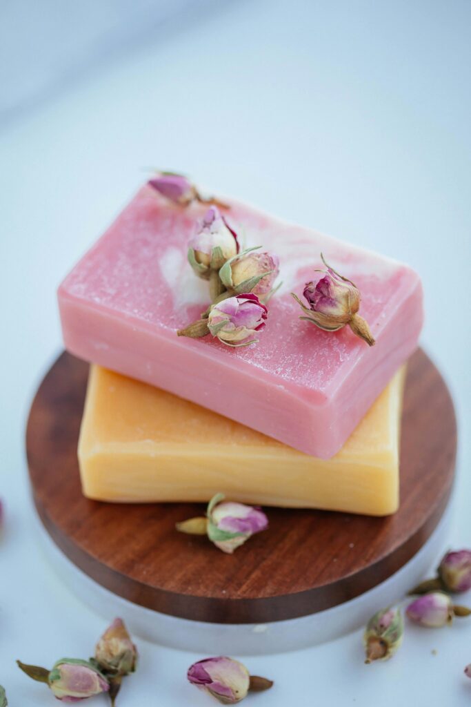 Close-up of vibrant soap bars adorned with dried rosebuds, symbolizing natural beauty.