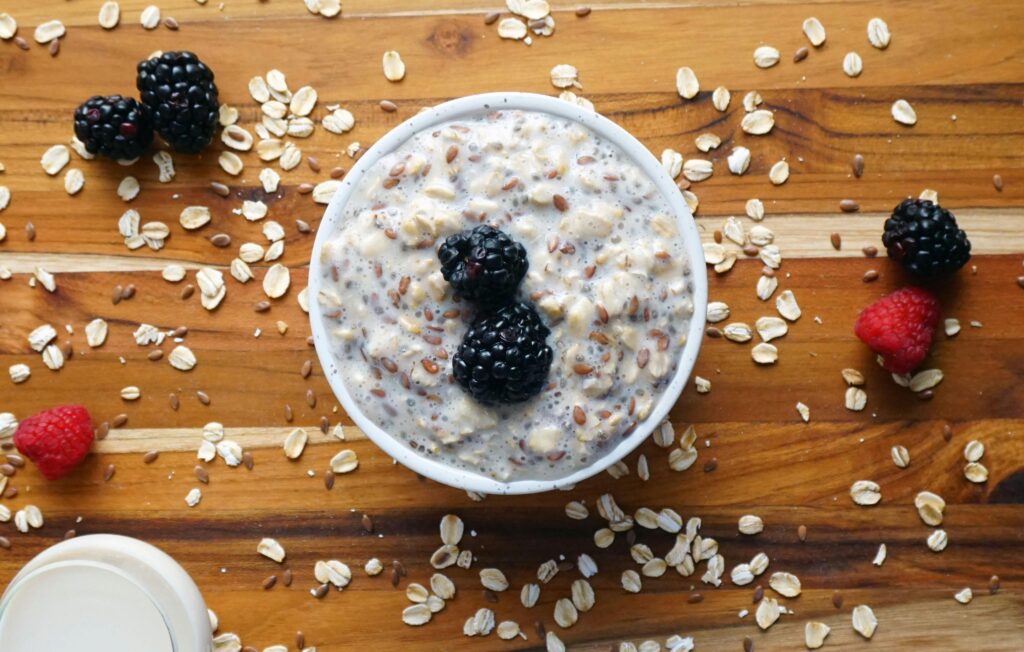 Delicious oatmeal bowl topped with fresh berries on a wooden table, perfect for a healthy breakfast.