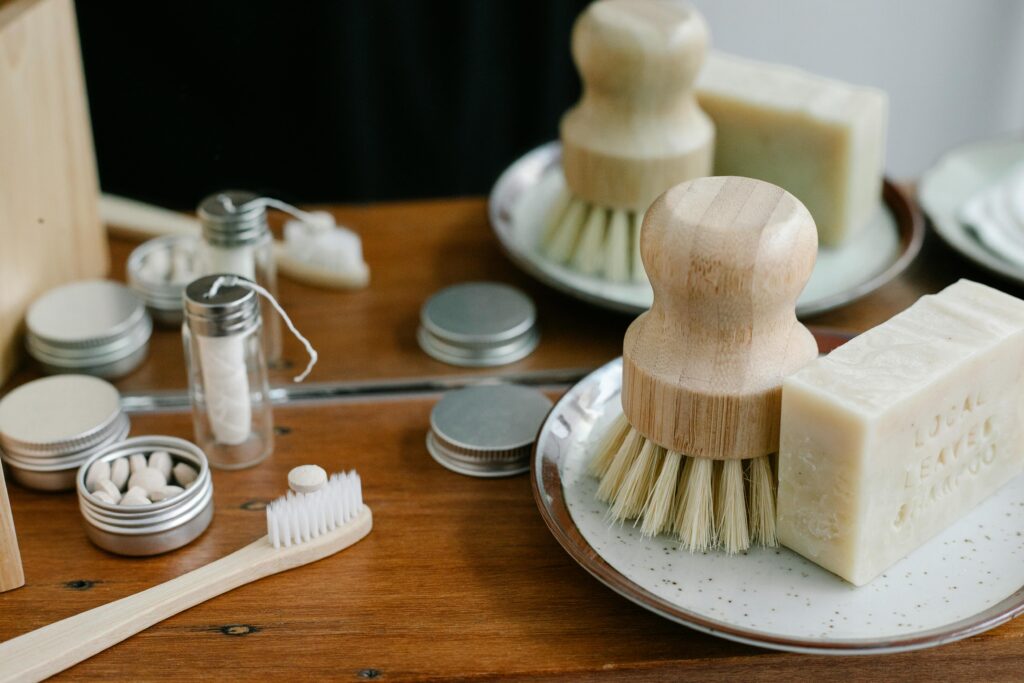 Eco-friendly bathroom essentials including bamboo toothbrush, soap, and reusable containers.